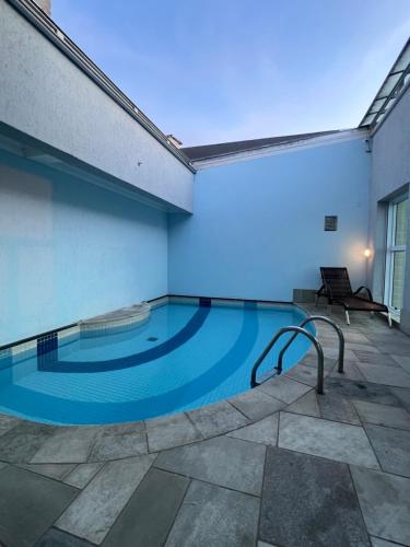 HOTEL PERDIZES - FLAT Executivo - 1403 في ساو باولو: مسبح في مبنى فيه اضاءة زرقاء