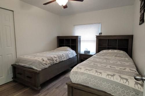a bedroom with two beds and a ceiling fan at 75 Acre home with trails & outdoor fun tons of Wildlife in Saint Charles