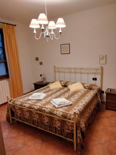 1 dormitorio con cama y lámpara de araña en Solerio 4, en Montescudaio