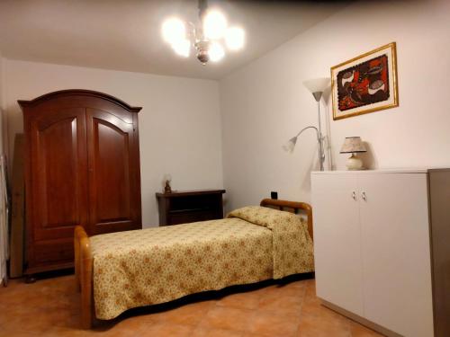1 dormitorio con 1 cama, armario y lámpara en Solerio 4 en Montescudaio