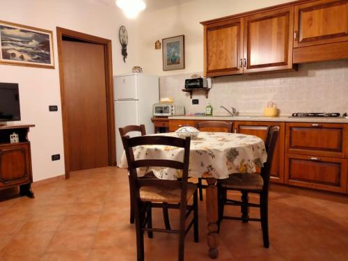 cocina con mesa y algunas sillas y cocina con mesa en Solerio 4 en Montescudaio
