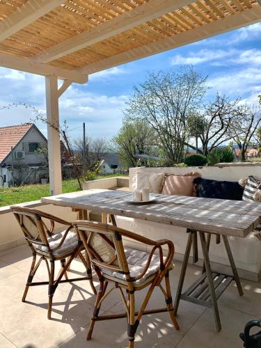 a wooden table and two chairs on a patio at Nagykulcsos Nyúlontúl in Mencshely
