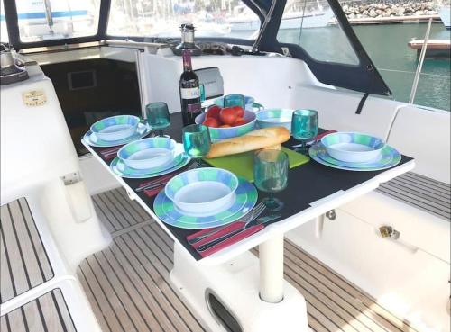 una mesa con platos y vasos en un barco en Brego, Velero para alojamiento, en Santa Cruz de Tenerife