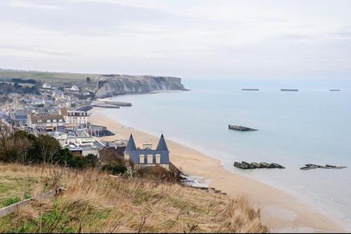 a view of a beach next to the ocean at Belle maison neuve à 5 mn de la plage in Colleville-Montgomery