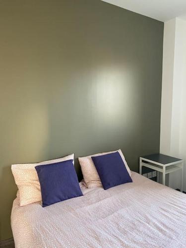 - un lit avec 2 oreillers violets dans l'établissement Belle maison neuve à 5 mn de la plage, à Colleville-Montgomery