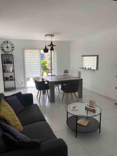 un salon avec un canapé et une table dans l'établissement Belle maison neuve à 5 mn de la plage, à Colleville-Montgomery