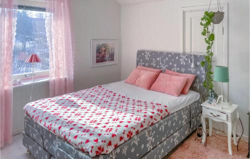 a bedroom with a bed with a red and white comforter at 3 Bedroom Nice Home In Lunde in Lunde