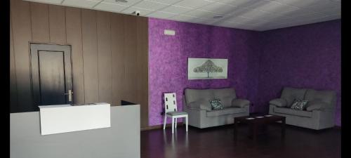 a living room with two chairs and purple walls at Las Talliscas in Casas de Don Gómez