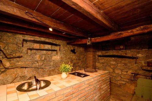 een badkamer met een wastafel en een stenen muur bij Villa Fani with Jacuzzi in Ičići