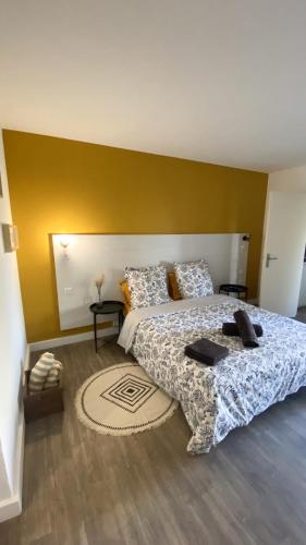 - une chambre avec un grand lit et un mur jaune dans l'établissement Joli Appartement 27m2 Terre d'Ocre en village vacances en Camargue, à Arles