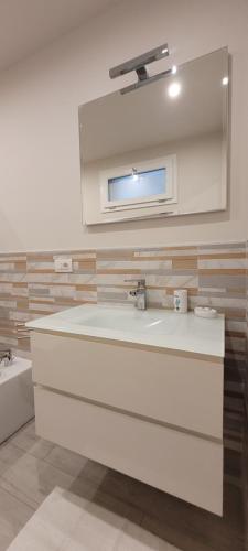 Baño blanco con lavabo y espejo en B and B da Magna Cichina en Collegno