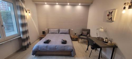 a bedroom with a bed and a table and a desk at B and B da Magna Cichina in Collegno