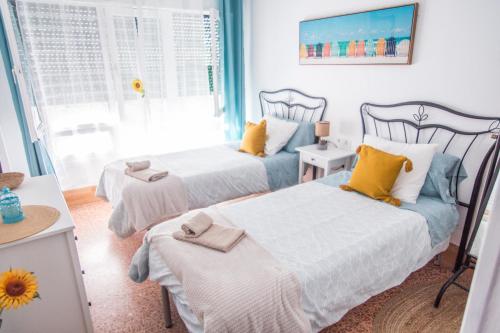 1 dormitorio con 2 camas y ventana en Mar y Sol, en Los Cancajos
