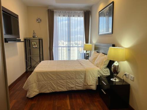 1 dormitorio con cama y ventana grande en Departamento Premium, categoría 5 estrellas, en Cochabamba