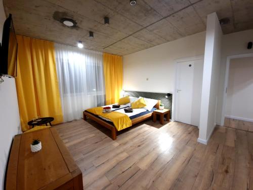 una camera con letto giallo e pavimento in legno di BIRD HOUSE a Prešov