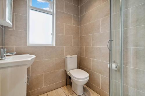 uma casa de banho com um WC, um lavatório e um chuveiro em Beautiful Cozy Room em Londres