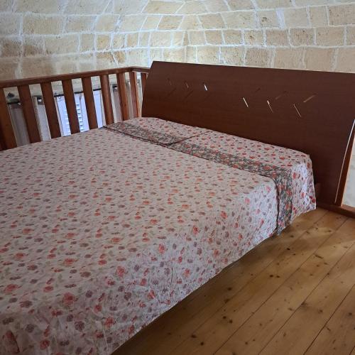 1 cama con sábanas florales en el suelo de madera en Maison Gio', en Taranto
