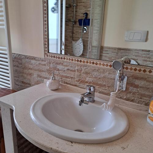 lavabo blanco en el baño con espejo en Maison Gio', en Taranto
