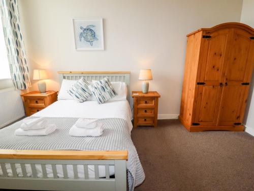 a bedroom with a bed with two towels on it at Yr Hen Festri in Llanddeiniolen