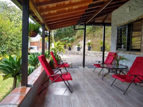 a patio with red chairs and a table on a porch at Cabaña la palma in Copacabana