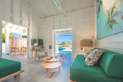 a living room with a green couch and a table at Villa Rackam in Terre-de-Haut