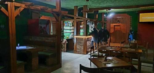 un restaurante con mesas de madera y sillas en una habitación en Ubytovanie KAMENICA, 