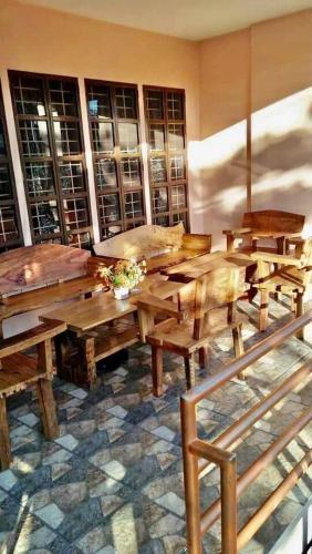a dining room with wooden tables and benches at Josephine's Home Donsol Sorsogon in Donsol