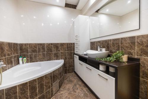 y baño con bañera y lavamanos. en Apartment Marina, en Novi Sad