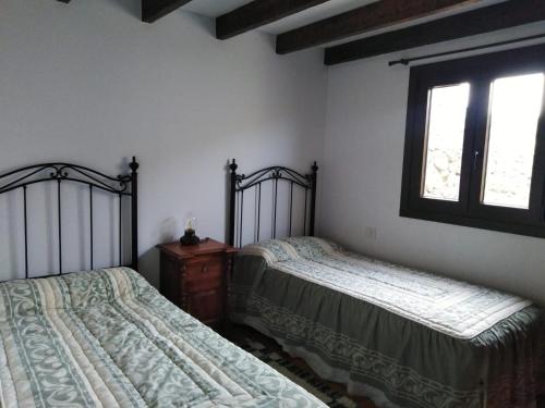 1 dormitorio con 2 camas y ventana en Casa Ben Abora en Las Rosas