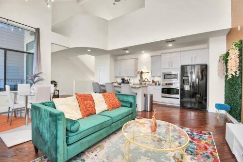 a living room with a green couch and a table at 3BR/3.5BA Three Story East Downtown TownHouse with view in Houston