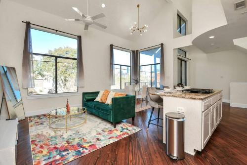 a living room with a green couch and a table at 3BR/3.5BA Three Story East Downtown TownHouse with view in Houston