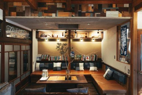 a room with a table and shelves with books at tabi-shiro in Matsumoto
