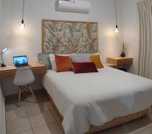 een slaapkamer met een groot bed en een laptop op een bureau bij Departamento en renta Cabos San lucas in Cabo San Lucas