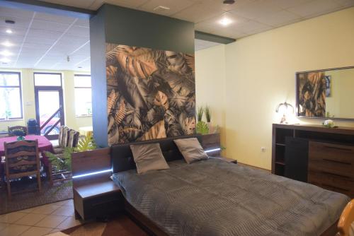 um quarto com uma cama com um quadro na parede em Apartament w Rynku em Pitschen