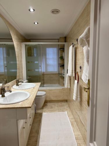 łazienka z 2 umywalkami i prysznicem w obiekcie Madera de Olmo w Madrycie