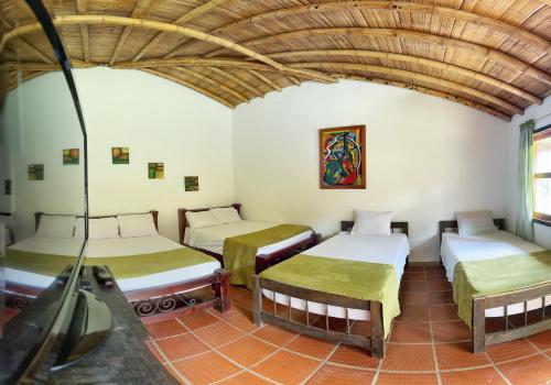 a room with three beds in a room at Finca Hotel Cabaña Fercho in Quimbaya