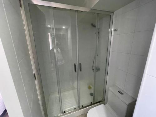 a glass shower in a bathroom with a toilet at Elegante y acogedor departamento con gran vista, cercano a todo in Concepción