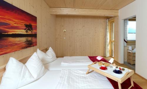a bedroom with a white bed and a table at Haus Maritchen in Kals am Großglockner