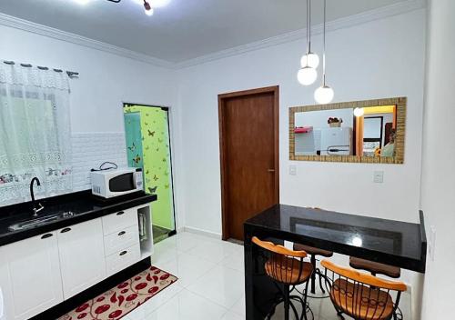 a kitchen with a black counter top and a sink at Cantinho de Maria in Aparecida