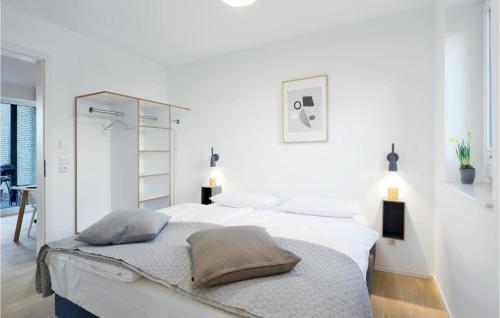 - une chambre blanche avec 2 lits et 2 lampes dans l'établissement Cozy Apartment In Lembruch-dmmer See With Kitchenette, à Lembruch
