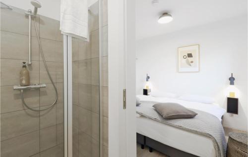 Elle comprend un lit et une salle de bains blanche pourvue d'une douche. dans l'établissement Cozy Apartment In Lembruch-dmmer See With Kitchenette, à Lembruch