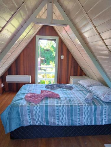 a bedroom with a bed in a attic at Cananéia Chalé 22 in Ilha Comprida