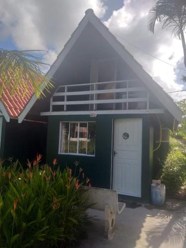 una casa azul con una puerta blanca en Cananéia Chalé 22 en Ilha Comprida