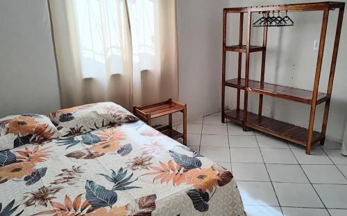 a bedroom with a bed with a floral comforter at Casa de Luís Correia in Luis Correia
