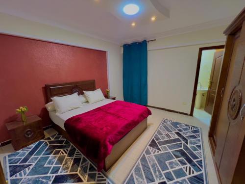 a bedroom with a large bed with a red blanket at سى فيو السريا in Alexandria