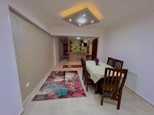 a dining room with a table and chairs and a rug at سى فيو السريا in Alexandria