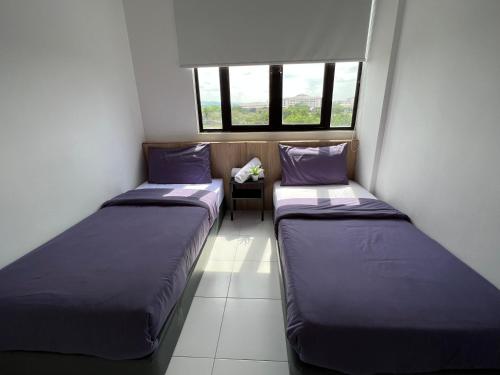 Habitación pequeña con 2 camas y 2 ventanas en Imperio Professional Suite by Mama Sue en Alor Setar