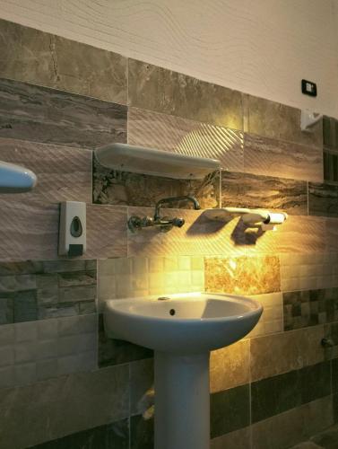 a bathroom with a white sink and a mirror at Friendo's House & Hot Spring in Siwa