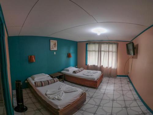 Cette chambre comprend 2 lits et une télévision. dans l'établissement Geliwa B&B, à Turrialba