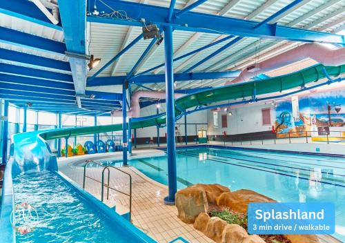 a swimming pool with a water slide in a building at COASTAL RETREAT Town Centre Entire Property, Very Close to Sea & Restaurants, 2 King Size Beds in Porthcawl